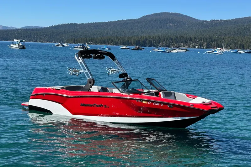 Slide: The Image of 2021 MasterCraft NXT24 boat in vibrant red on a scenic lake. - 3