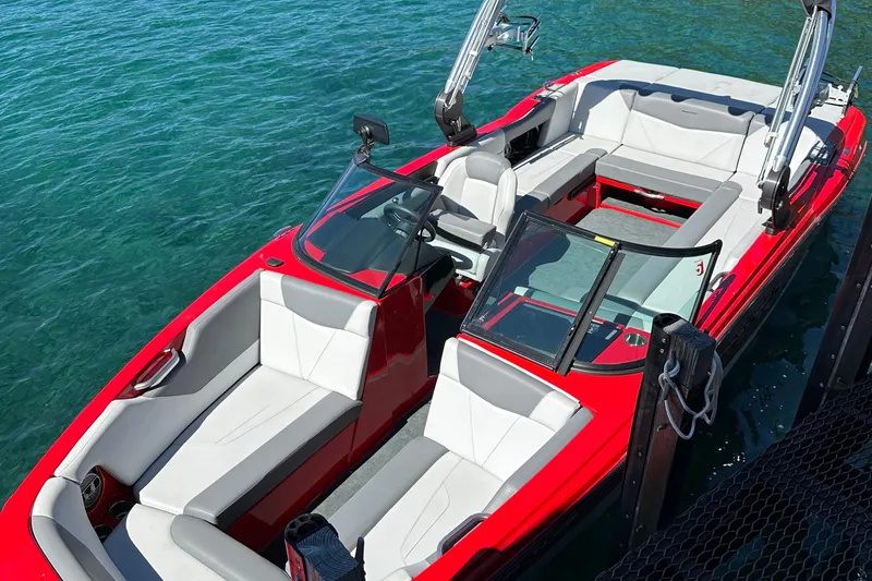 Slide: The Image of 2021 MasterCraft NXT24 boat with red exterior and white seating on clear water. - 5