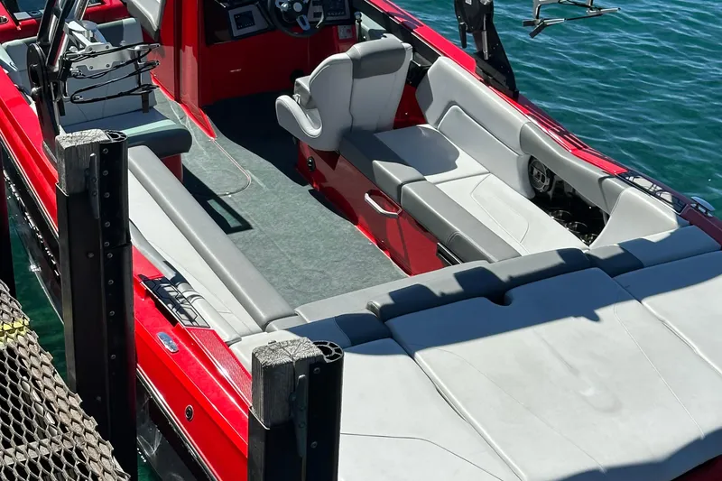 Slide: The Image of 2021 MasterCraft NXT24 boat interior with red and gray seating on water. - 7