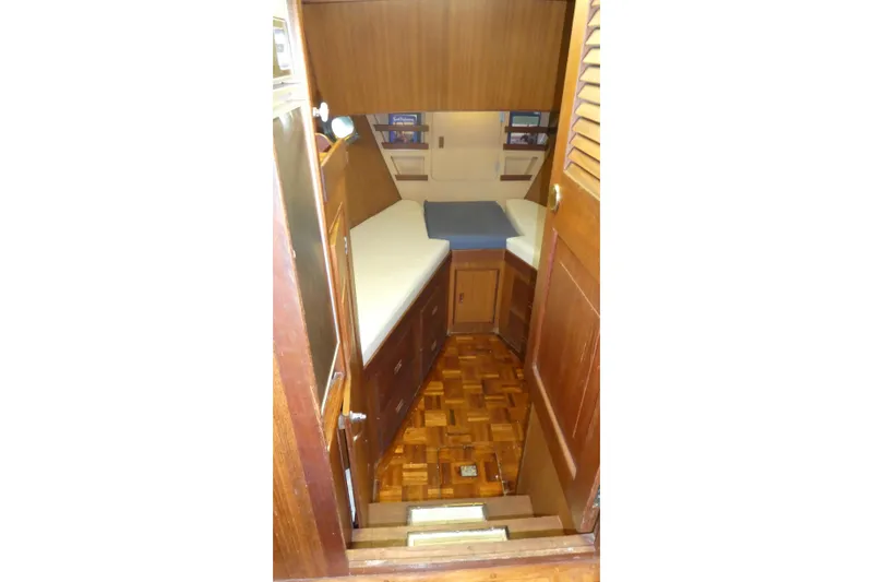 Slide: The Image of 1979 Hiptimco 40' Trawler cabin interior with wooden finish and cozy bedding. - 10