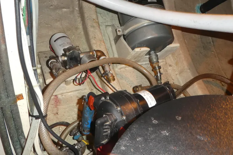 Slide: The Image of Engine room components of a 1979 Hiptimco 40' Trawler, featuring hoses and machinery. - 41