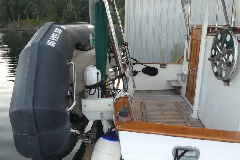 Slide: The Image of 1979 Hiptimco 40' Trawler docked with inflatable boat and wooden deck. - 44