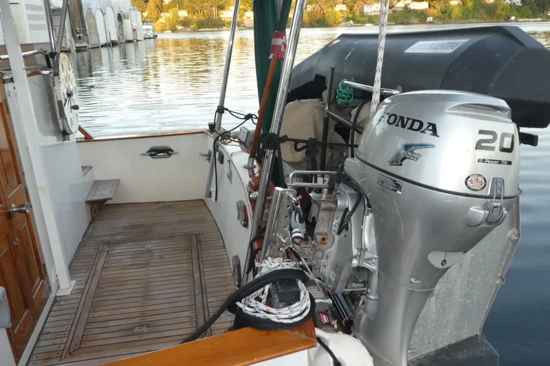 Slide: The Image of 1979 Hiptimco 40' Trawler with Honda 20 outboard motor, docked on calm water. - 45