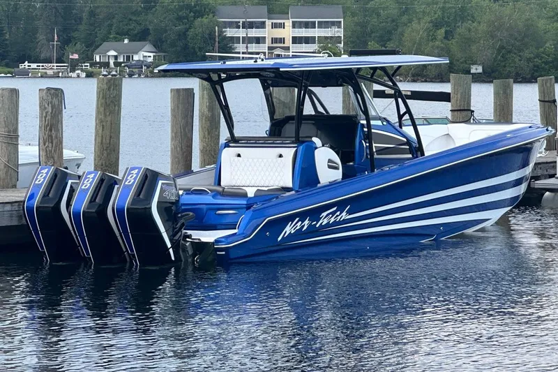 Slide: The Image of 2025 Nor-Tech 340 Sport Center Console boat docked with triple engines. - 18