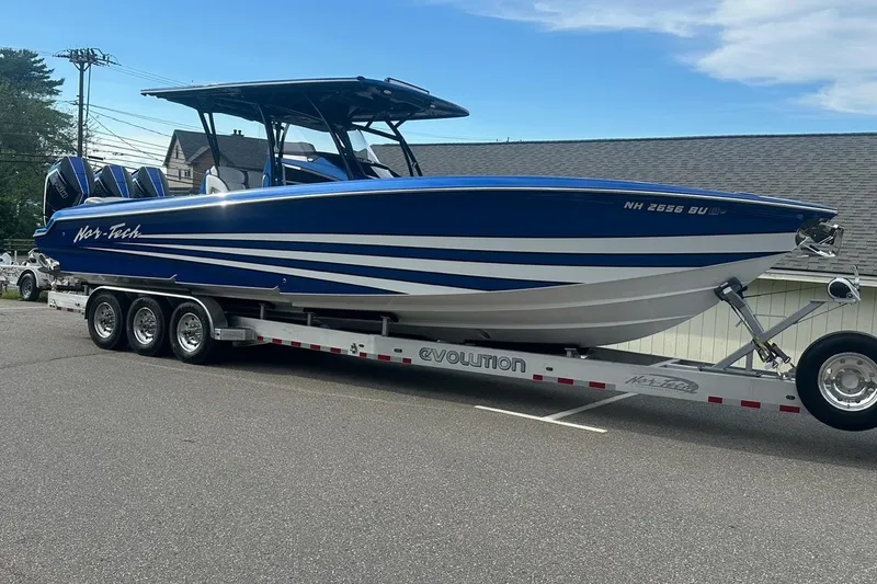 Slide: The Image of 2025 Nor-Tech 340 Sport Center Console boat on trailer, blue and white design. - 19