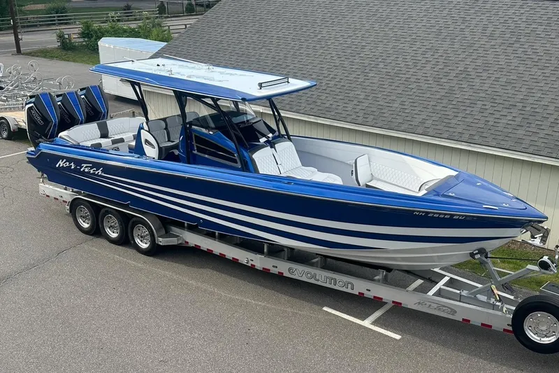 Slide: The Image of 2025 Nor-Tech 340 Sport Center Console boat on trailer, blue and white design. - 21
