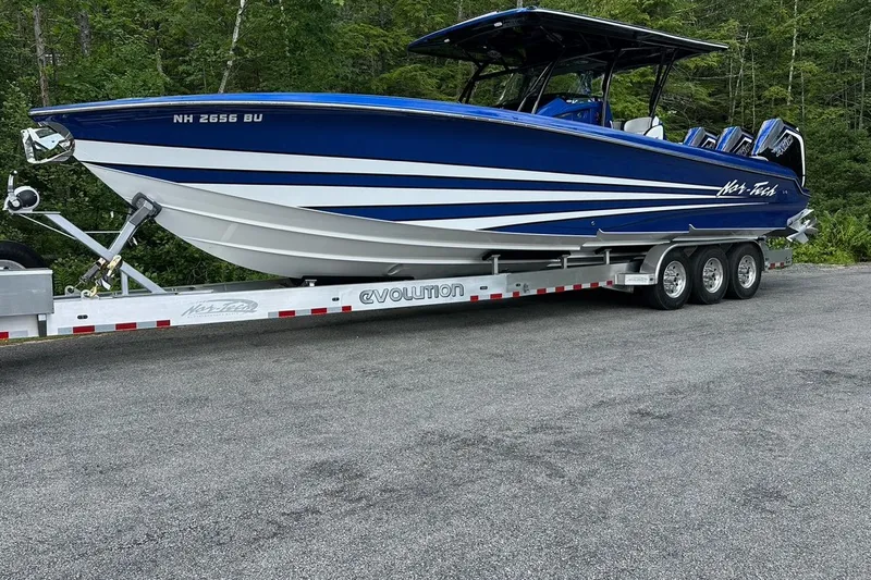 Slide: The Image of 2025 Nor-Tech 340 Sport Center Console boat on trailer, blue and white design. - 22