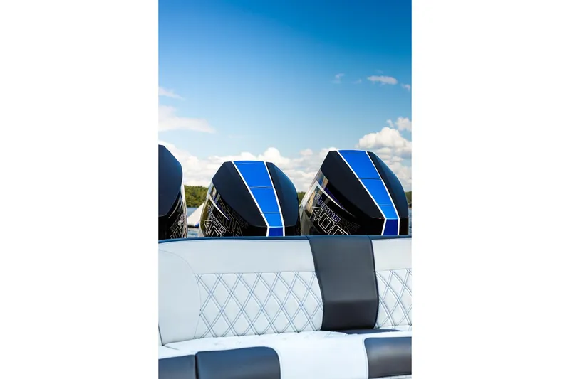 Slide: The Image of 2025 Nor-Tech 340 Sport Center Console with triple outboard engines, blue sky background. - 25