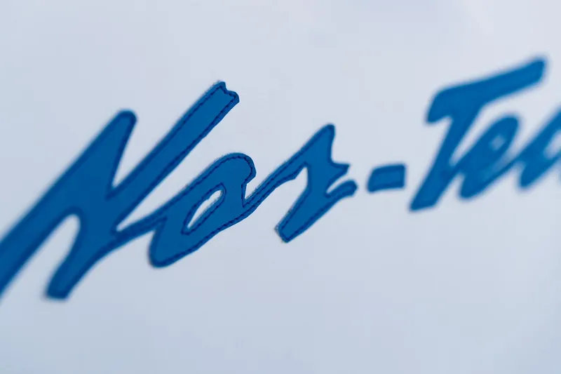 Slide: The Image of Close-up of Nor-Tech logo on 2025 340 Sport Center Console boat. - 28