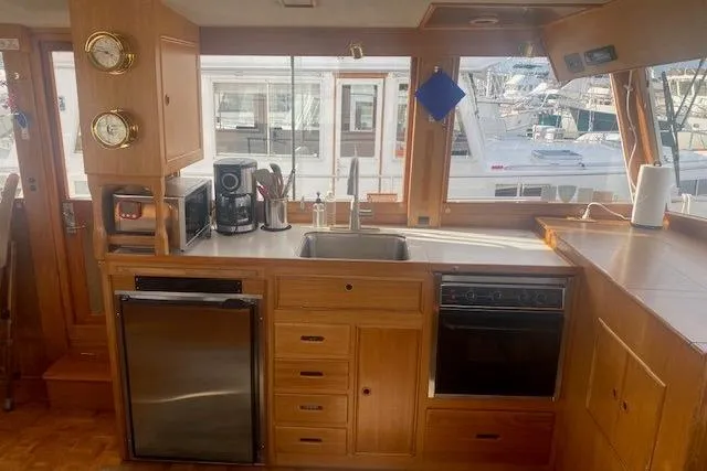 Slide: The Image of 1990 Grand Banks Classic yacht kitchen with wooden cabinetry and modern appliances. - 10