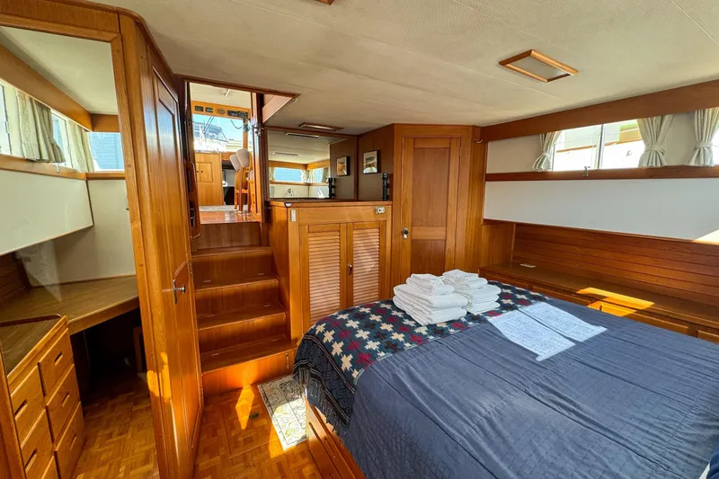 Slide: The Image of Luxurious 1990 Grand Banks Classic yacht interior with wood paneling and cozy bedroom. - 12