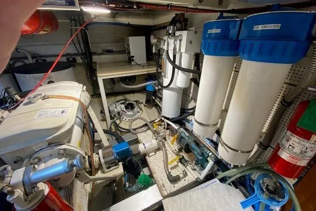 Slide: The Image of Engine room of a 1990 Grand Banks Classic yacht, featuring filtration systems and equipment. - 15