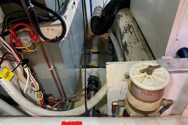 Slide: The Image of Engine room of 1990 Grand Banks Classic boat with visible wiring and Racor fuel filter. - 19