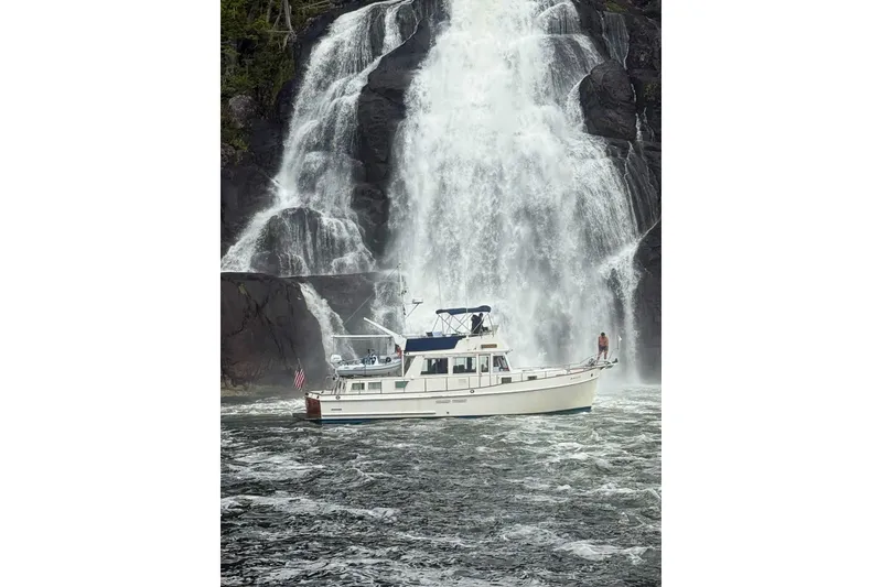 Slide: The Image of Grand Banks Classic 1990 yacht near a majestic waterfall. - 27
