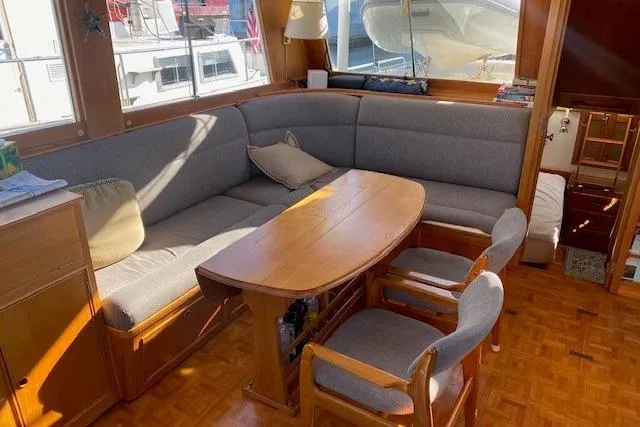 Slide: The Image of Cozy interior of 1990 Grand Banks Classic yacht with wooden table and cushioned seating. - 5