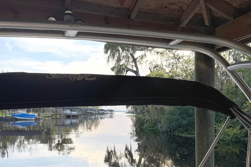 Slide: The Image of 2005 Sea Ray 240 Sundeck boat docked by a serene lakeside view. - 38