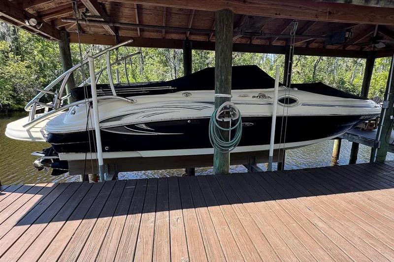 Slide: The Image of 2005 Sea Ray 240 Sundeck boat docked under wooden shelter. - 42