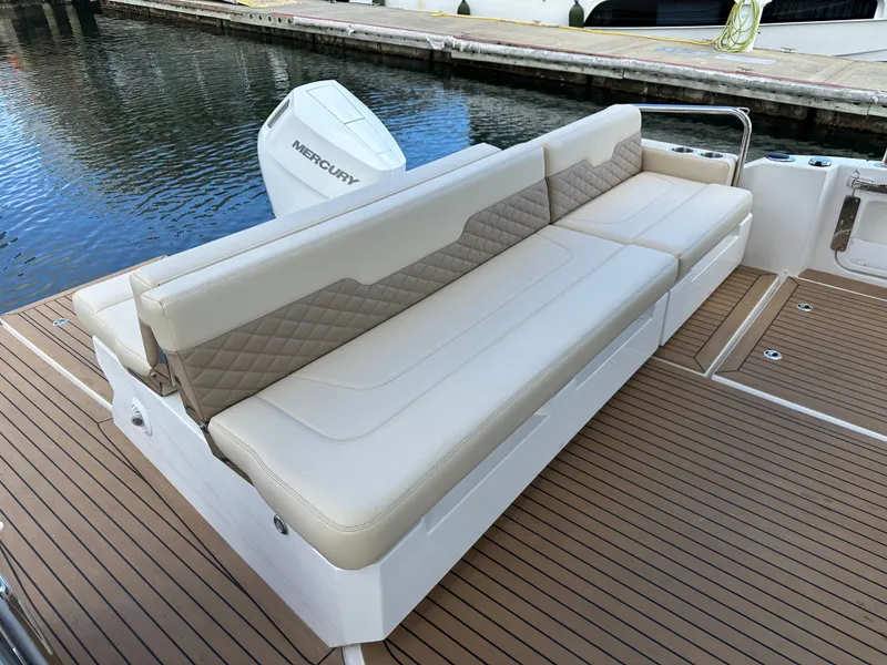 Slide: The Image of Luxury seating on 2025 Aquila 36 Sport boat with Mercury engine, docked by the water. - 13