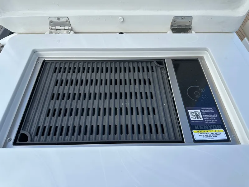 Slide: The Image of Built-in grill on 2025 Aquila 36 Sport boat, featuring Kenyon electric cooktop. - 14