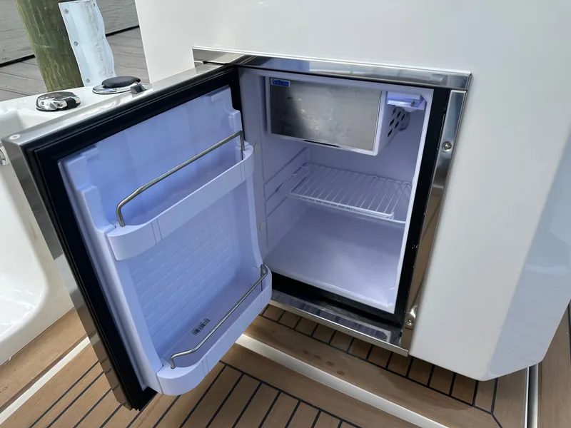 Slide: The Image of Open mini fridge on Aquila 36 Sport 2025 boat, showing interior shelves and freezer compartment. - 15