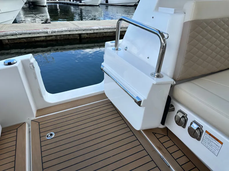 Slide: The Image of Aquila 36 Sport 2025 boat interior with teak flooring and cushioned seating. - 19