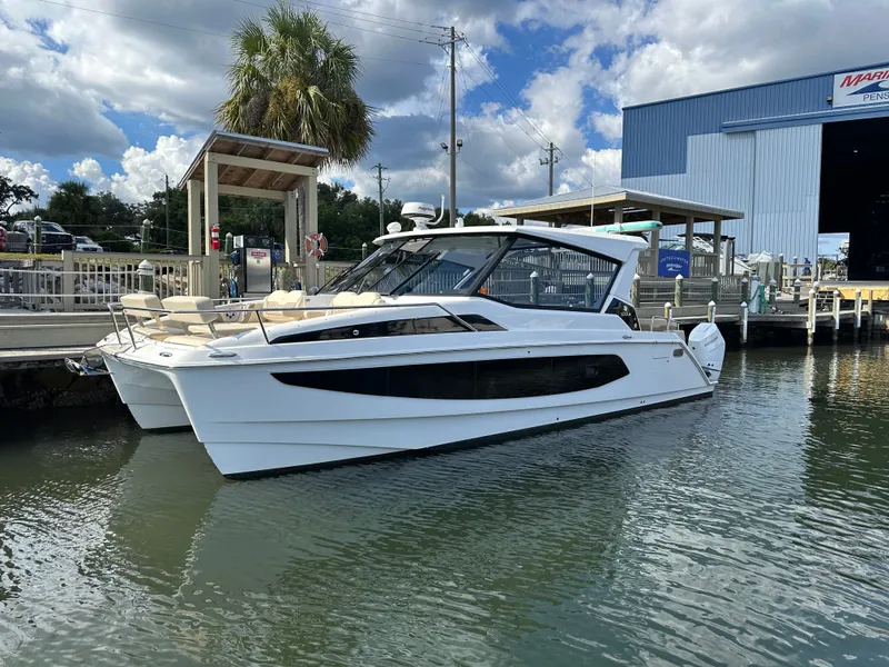 Slide: The Image of 2025 Aquila 36 Sport boat docked at marina under cloudy sky. - 2
