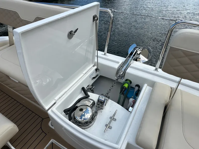 Slide: The Image of Aquila 36 Sport 2025 boat anchor compartment with open lid, showing chain and winch. - 21