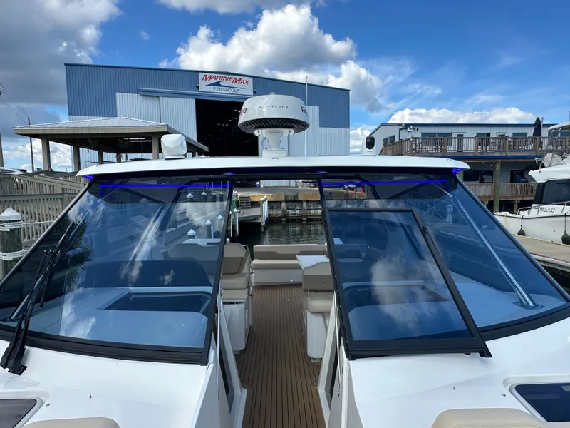 Slide: The Image of 2025 Aquila 36 Sport boat docked at MarineMax Pensacola under a blue sky. - 22