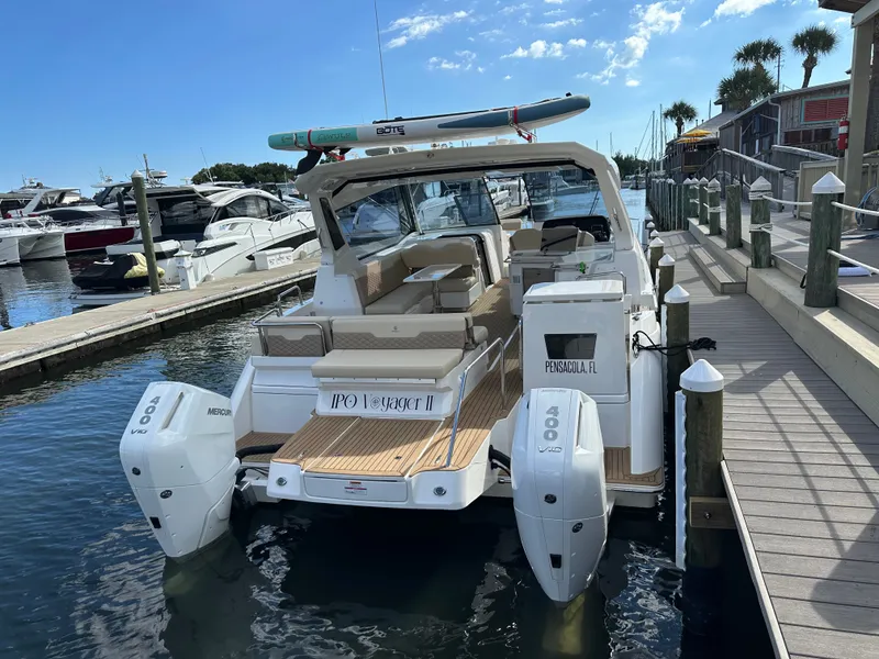 Slide: The Image of 2025 Aquila 36 Sport boat docked, featuring twin Mercury 400 engines, in a marina setting. - 5