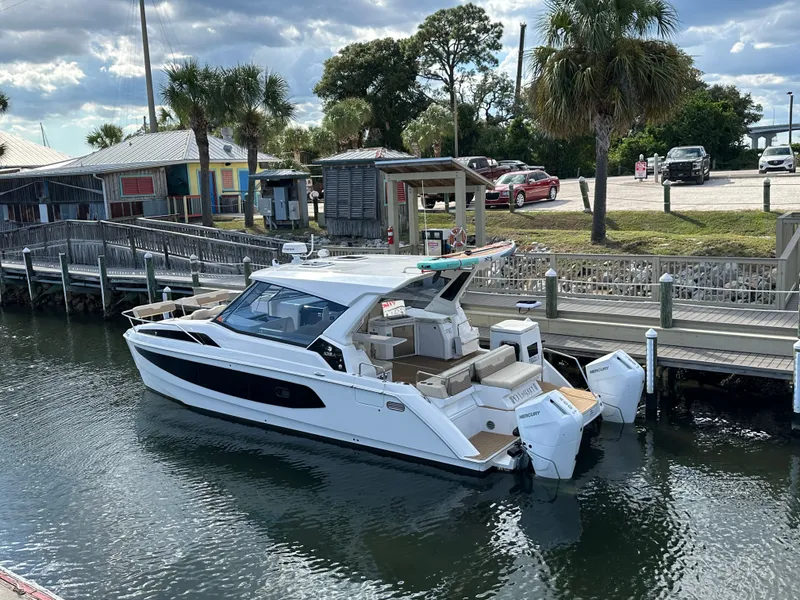 Slide: The Image of Aquila 36 Sport 2025 docked by a wooden pier with palm trees nearby. - 6