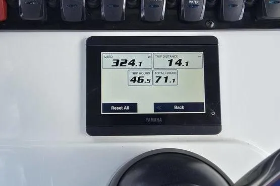 Slide: The Image of 2023 Sea Hunt Ultra 234 boat console with steering wheel and electronics, under a blue sky. - 11