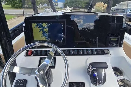 Slide: The Image of 2023 Sea Hunt Ultra 234 boat dashboard with steering wheel and controls. - 16
