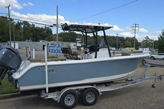 Slide: The Image of 2023 Sea Hunt Ultra 234 boat on trailer, parked outdoors with trees in background. - 5