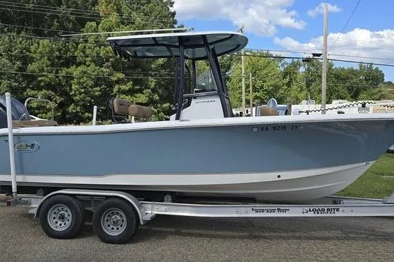 Slide: The Image of 2023 Sea Hunt Ultra 234 boat on trailer, parked outdoors under blue sky. - 6