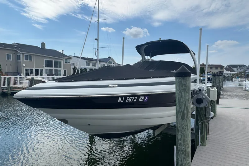 The Image of 2015 Crownline 285 SS boat docked at marina, covered and elevated. - 0