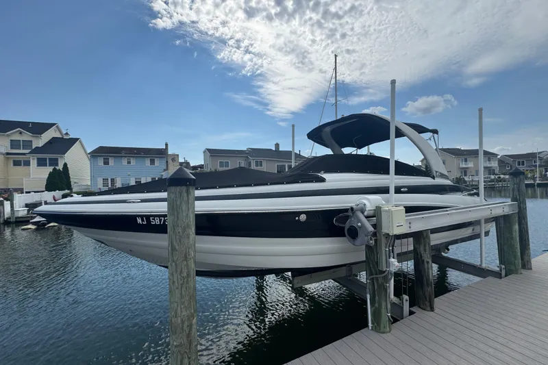 Slide: The Image of 2015 Crownline 285 SS boat docked at a marina under a partly cloudy sky. - 11