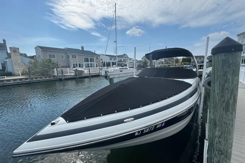 Slide: The Image of 2015 Crownline 285 SS boat docked in a marina, covered and ready for use. - 13