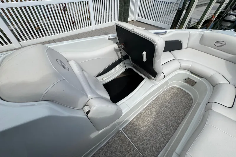 Slide: The Image of 2015 Crownline 285 SS boat interior with open storage compartment and cushioned seating. - 20