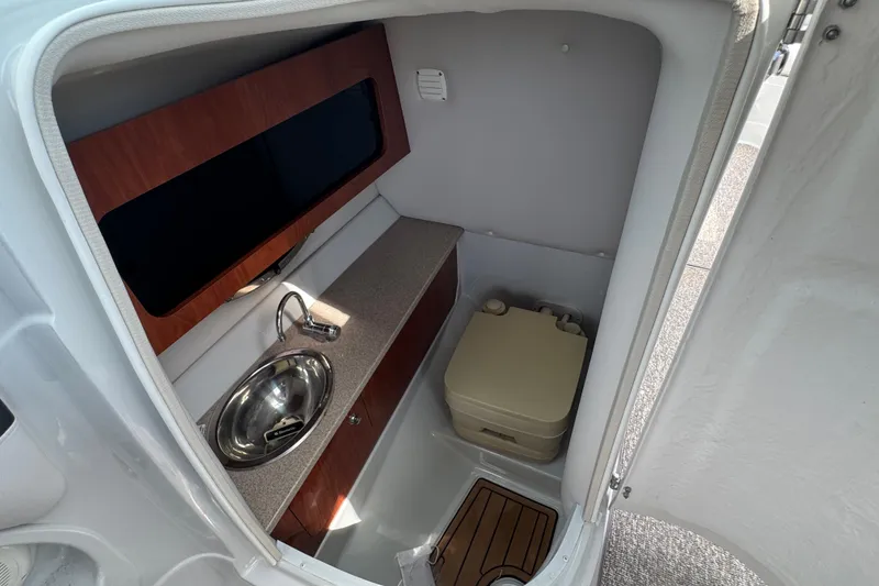 Slide: The Image of 2015 Crownline 285 SS boat interior with sink and portable toilet. - 23