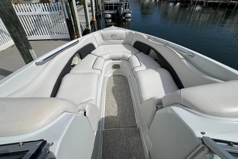 Slide: The Image of 2015 Crownline 285 SS boat interior with white seating, docked by the water. - 26