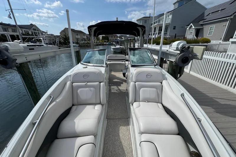 Slide: The Image of 2015 Crownline 285 SS boat docked, featuring spacious seating and sleek design. - 28
