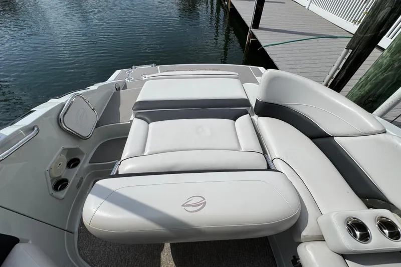 Slide: The Image of 2015 Crownline 285 SS boat interior with white leather seating by the dock. - 43