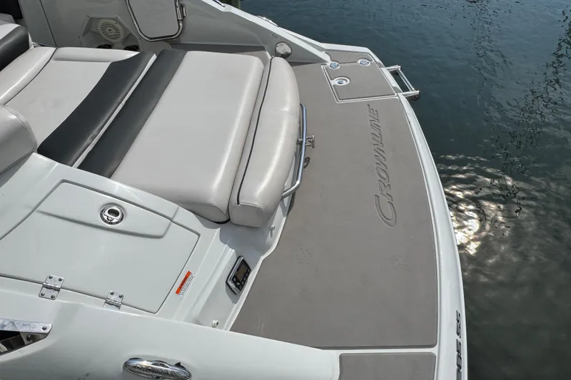 Slide: The Image of 2015 Crownline 285 SS boat with cushioned seating and swim platform by the water. - 45