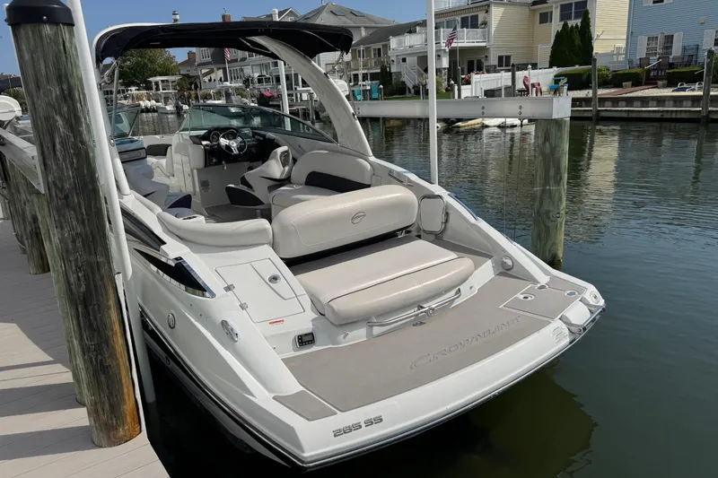 Slide: The Image of 2015 Crownline 285 SS boat docked in a marina, showcasing sleek design and spacious seating. - 48