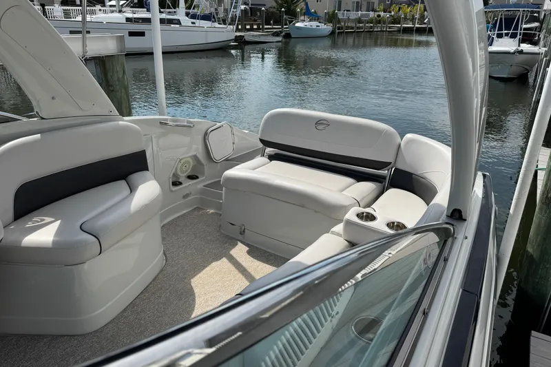 Slide: The Image of 2015 Crownline 285 SS boat interior with plush seating, docked in a marina. - 51