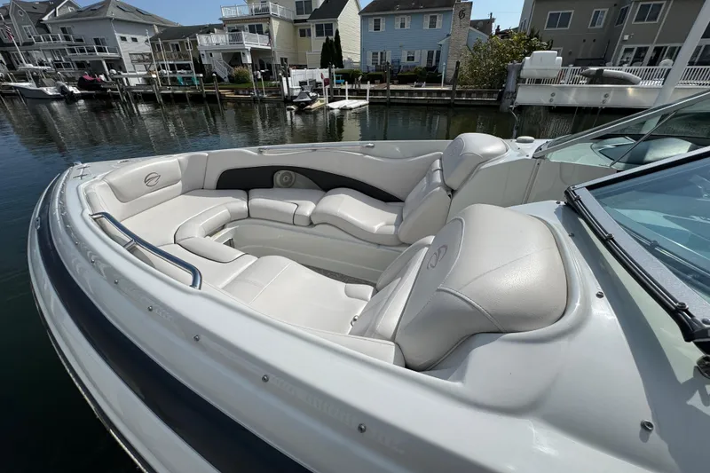 Slide: The Image of 2015 Crownline 285 SS boat with luxurious seating, docked near waterfront homes. - 53