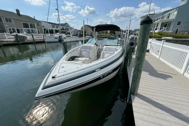 Slide: The Image of 2015 Crownline 285 SS boat docked at a marina under a partly cloudy sky. - 54