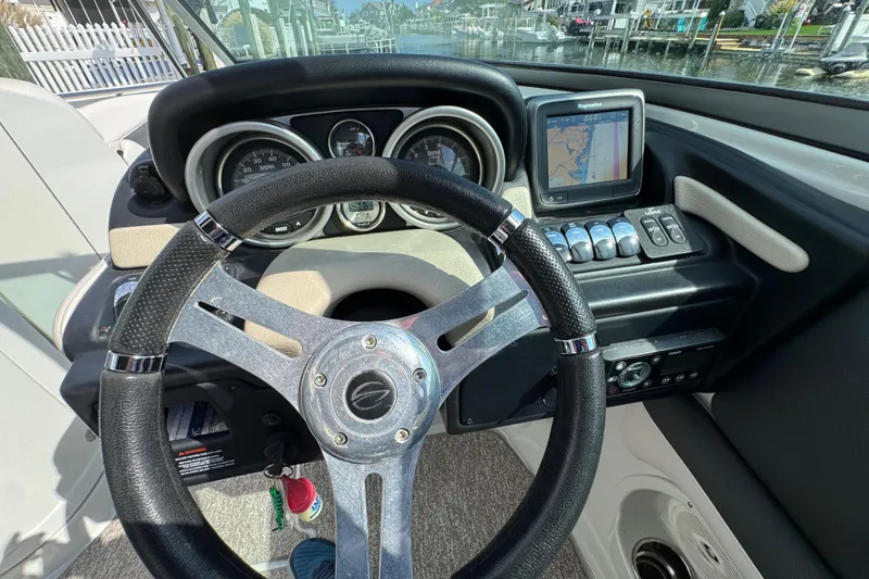 Slide: The Image of Steering wheel and dashboard of 2015 Crownline 285 SS boat with navigation system. - 56
