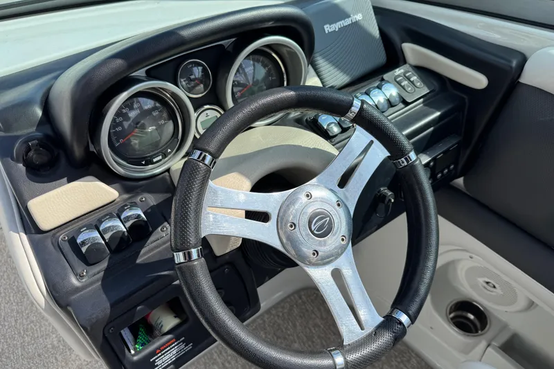 Slide: The Image of Steering wheel and dashboard of 2015 Crownline 285 SS boat, featuring gauges and controls. - 59