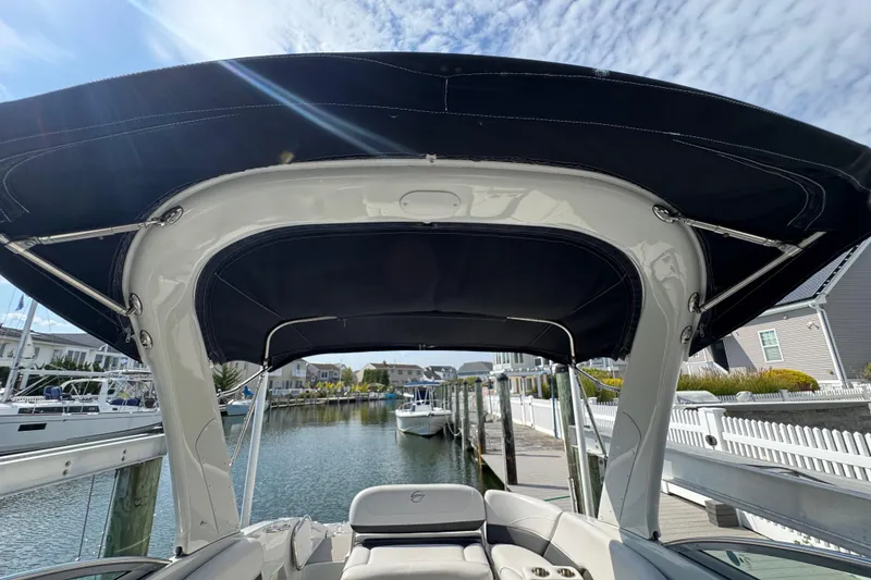 Slide: The Image of 2015 Crownline 285 SS boat with canopy docked in a marina. - 64
